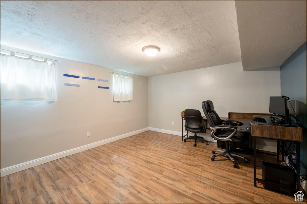 Office featuring light hardwood / wood-style floors and a textured ceiling