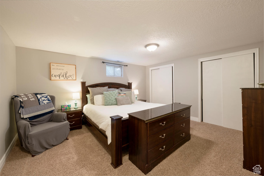 Bedroom featuring light carpet and a textured ceiling