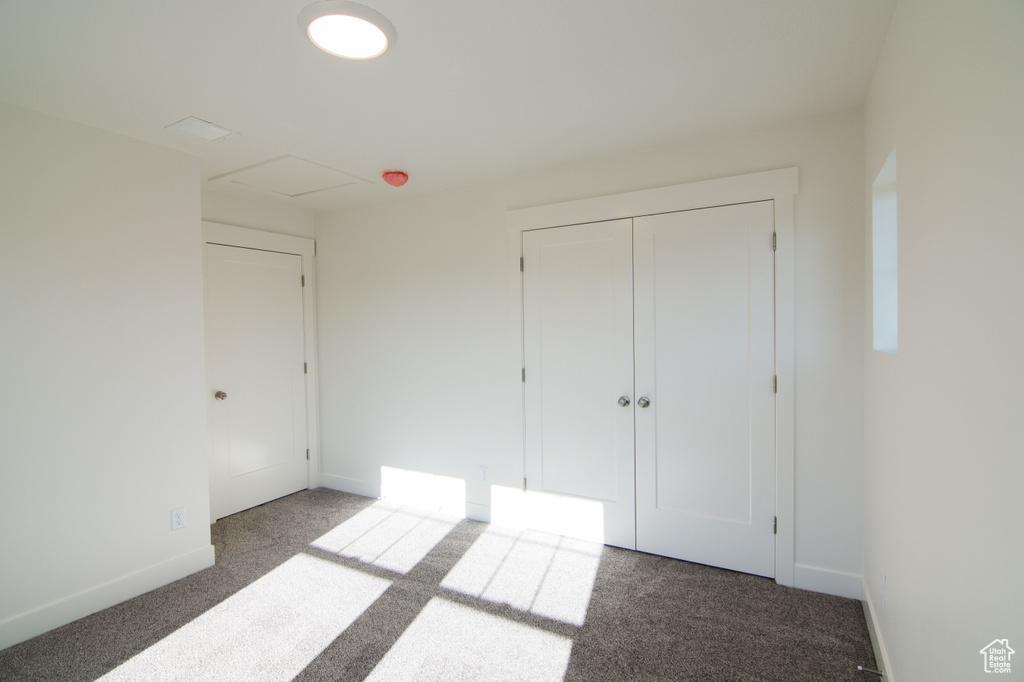 Unfurnished bedroom featuring carpet flooring and a closet