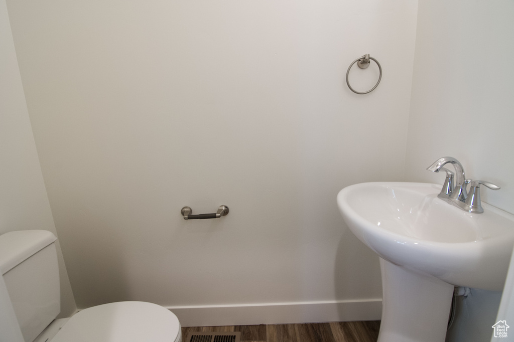 Bathroom with toilet and hardwood / wood-style flooring