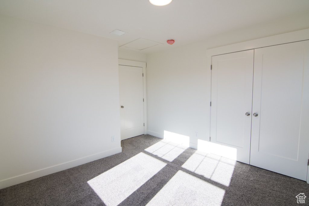 Unfurnished bedroom featuring light carpet and a closet