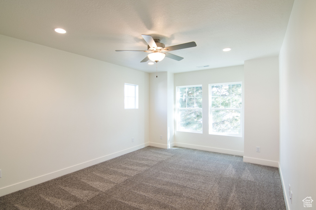 Carpeted empty room featuring ceiling fan