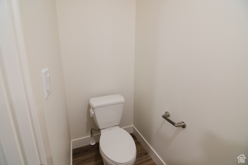 Bathroom with hardwood / wood-style flooring and toilet