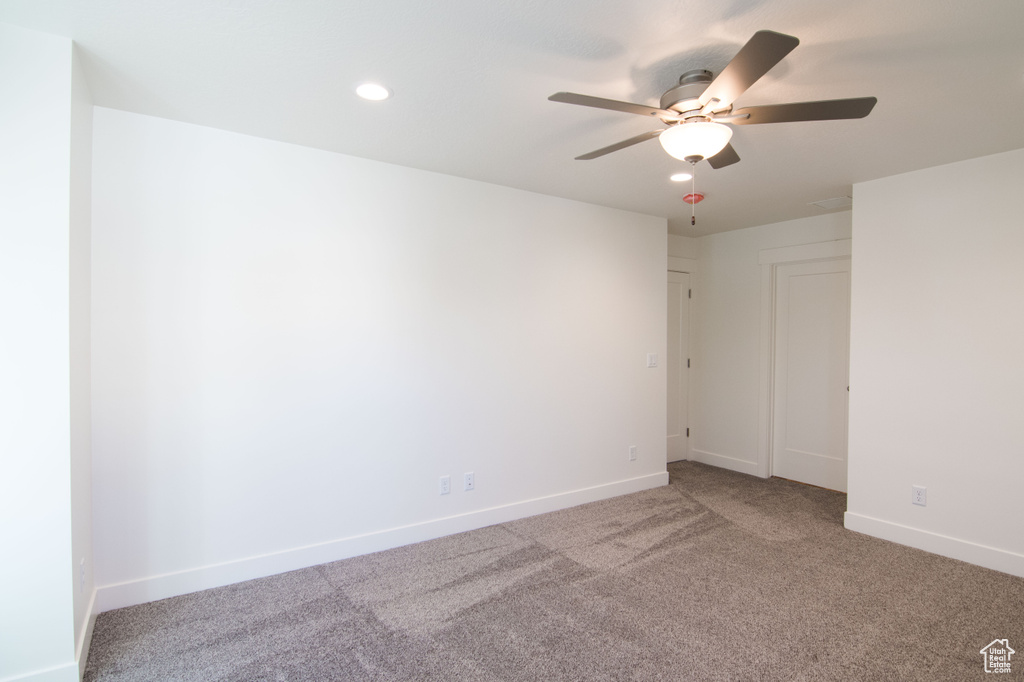 Carpeted empty room with ceiling fan