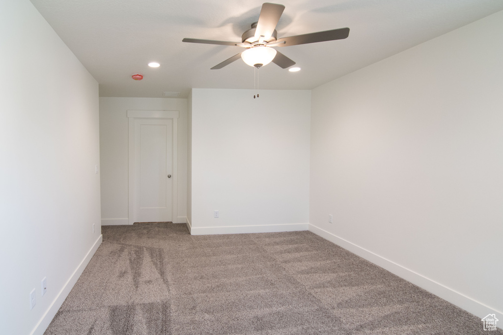 Carpeted empty room with ceiling fan