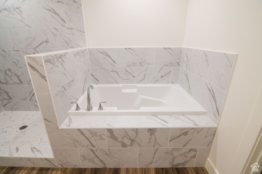 Bathroom featuring shower with separate bathtub and hardwood / wood-style floors