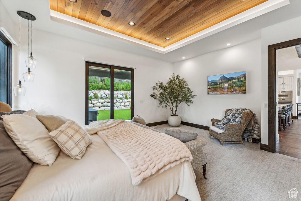 Bedroom with wooden ceiling, a tray ceiling, and hardwood / wood-style floors