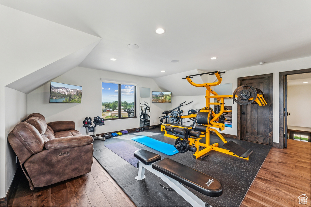 Workout area with lofted ceiling and hardwood / wood-style flooring