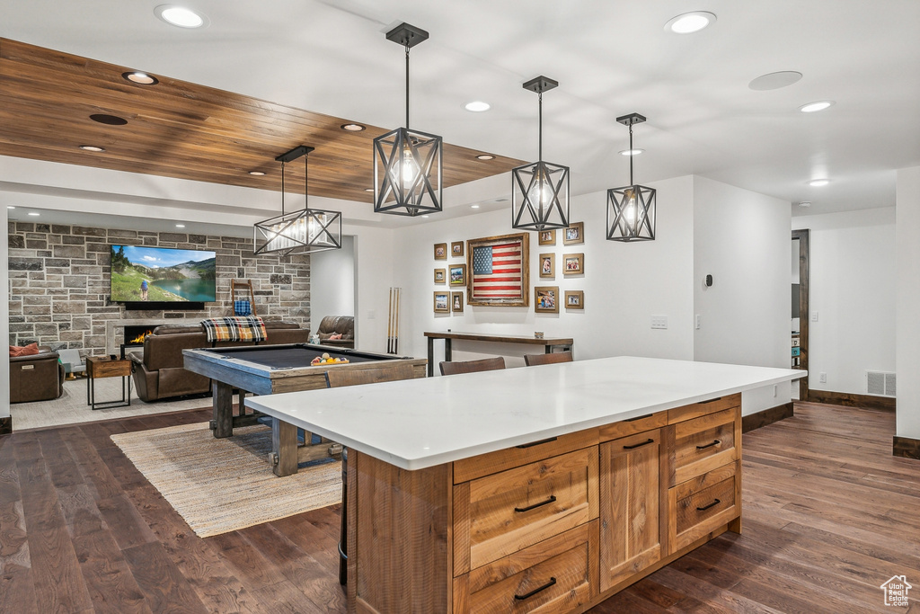 Kitchen featuring dark hardwood / wood-style flooring, a center island, wooden ceiling, billiards, and decorative light fixtures