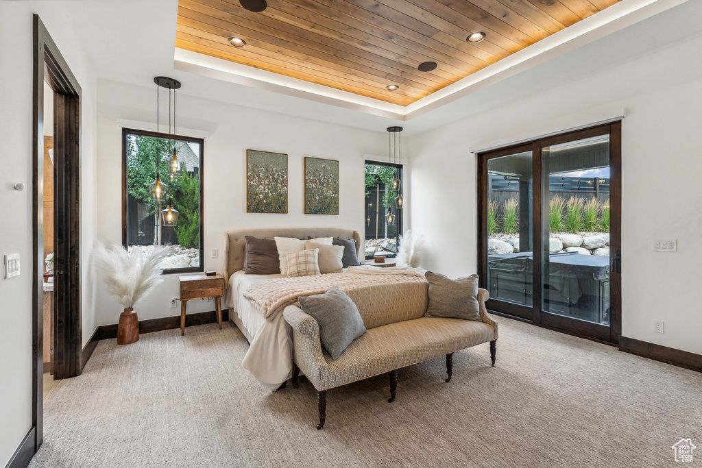 Carpeted bedroom featuring access to exterior, a raised ceiling, and wooden ceiling