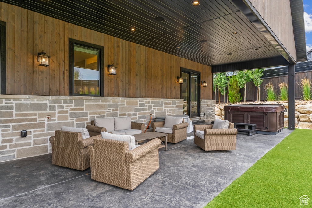 View of patio / terrace featuring a hot tub and an outdoor living space