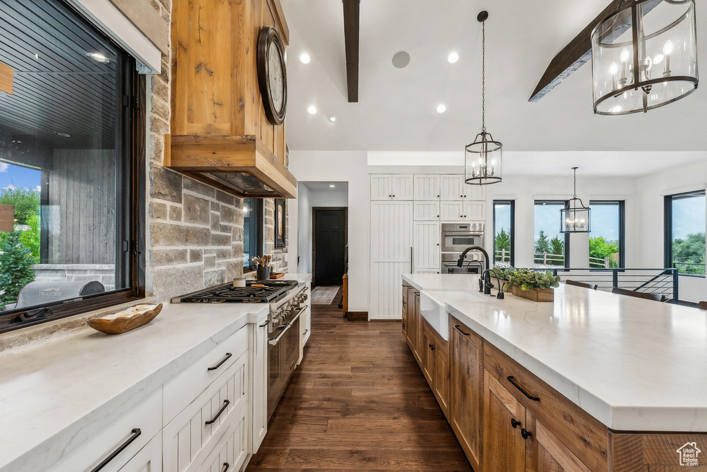 Kitchen featuring sink, beamed ceiling, stainless steel appliances, and dark wood-type flooring