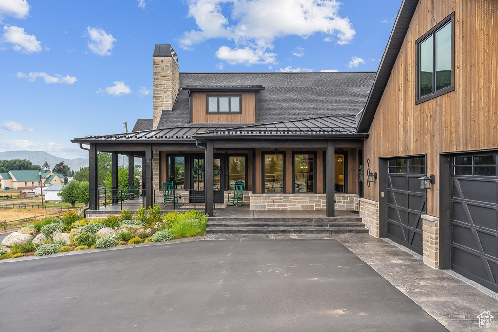 Exterior space featuring a garage and covered porch