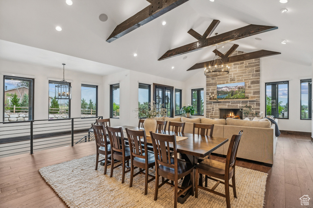 Dining space featuring beamed ceiling, a fireplace, light hardwood / wood-style flooring, and brick wall