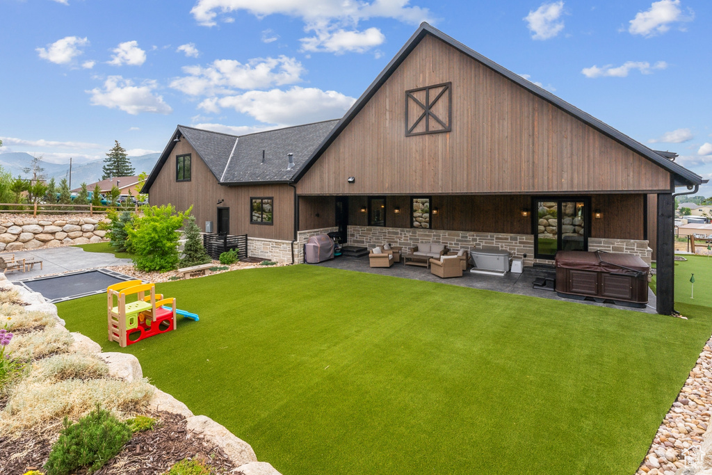 Back of house with a patio, an outdoor living space, and a yard