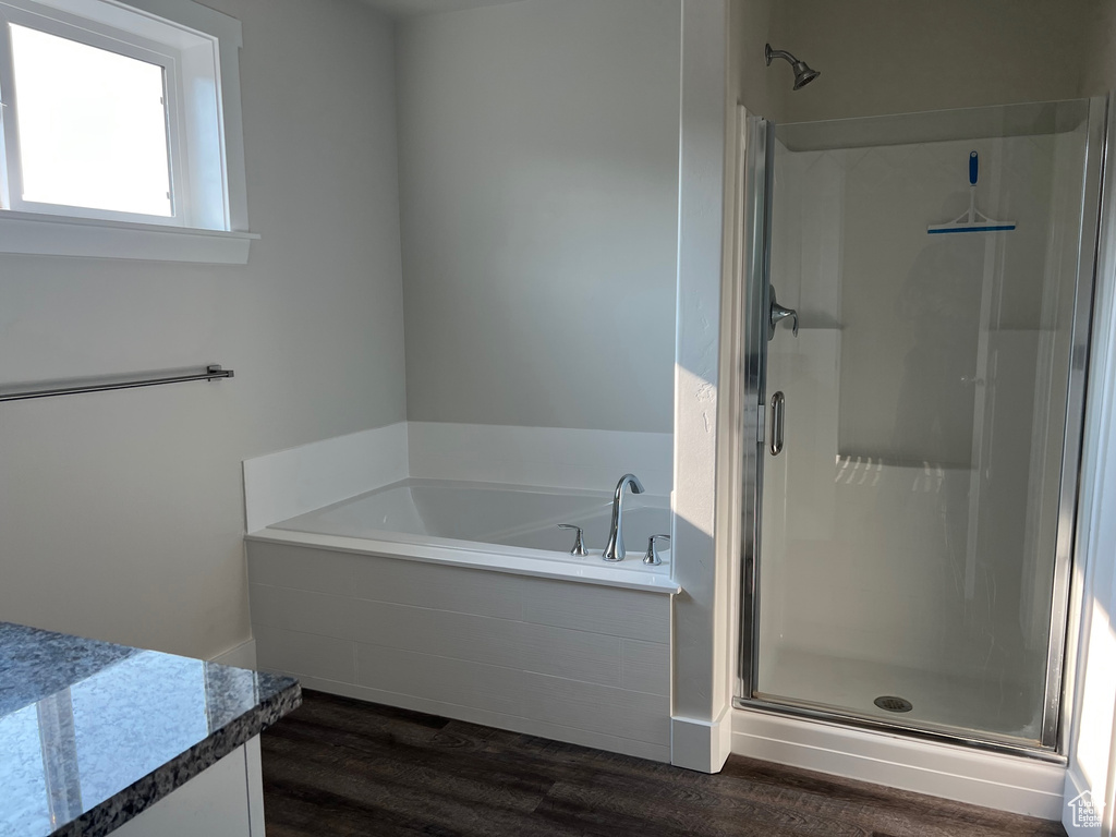 Bathroom featuring shower with separate bathtub, hardwood / wood-style floors, and vanity