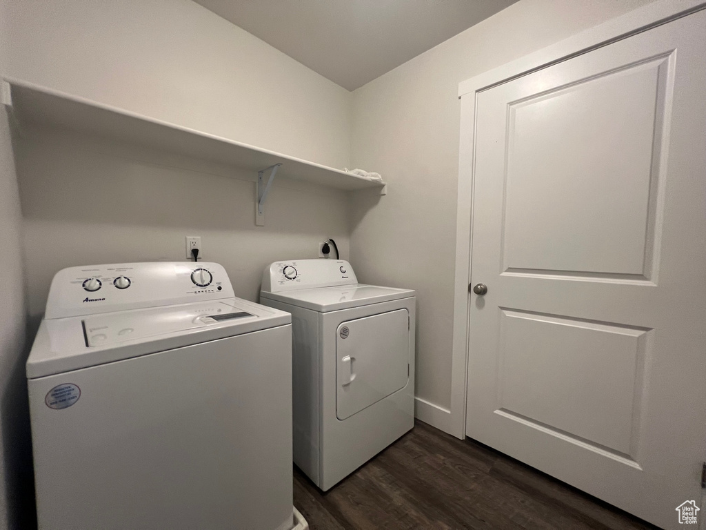 Laundry room featuring washer and dryer and dark wood-type flooring