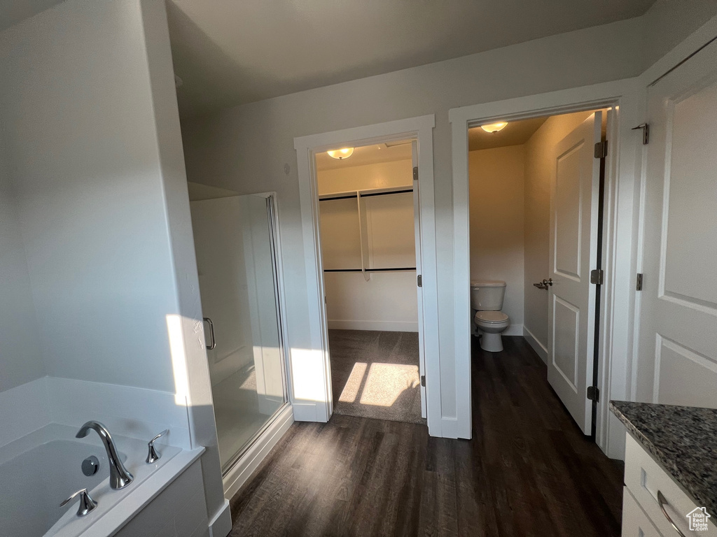 Full bathroom featuring independent shower and bath, toilet, vanity, and hardwood / wood-style floors