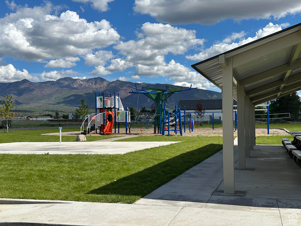 View of jungle gym with a lawn and a mountain view