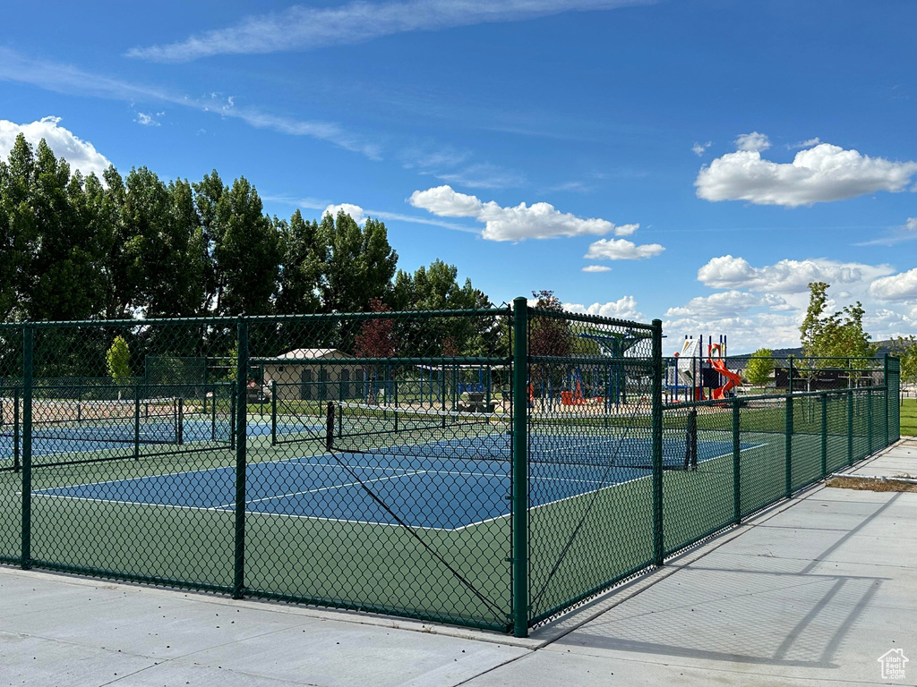 View of tennis court with a playground