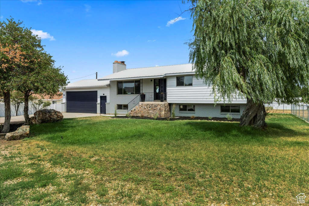 View of front of house featuring a garage and a front lawn