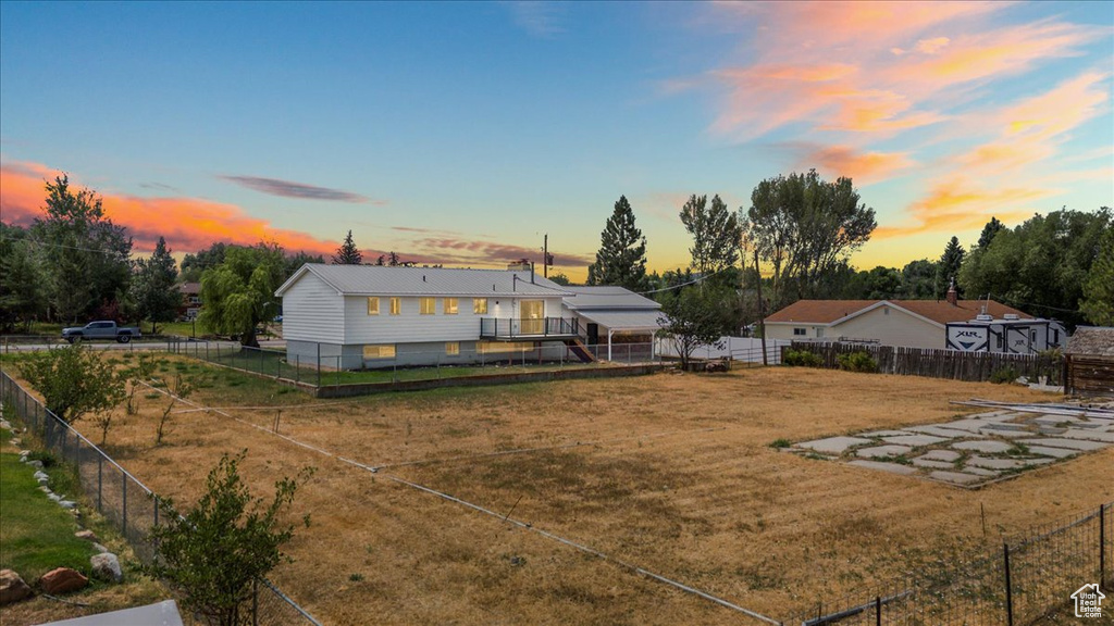 Back house at dusk with a yard