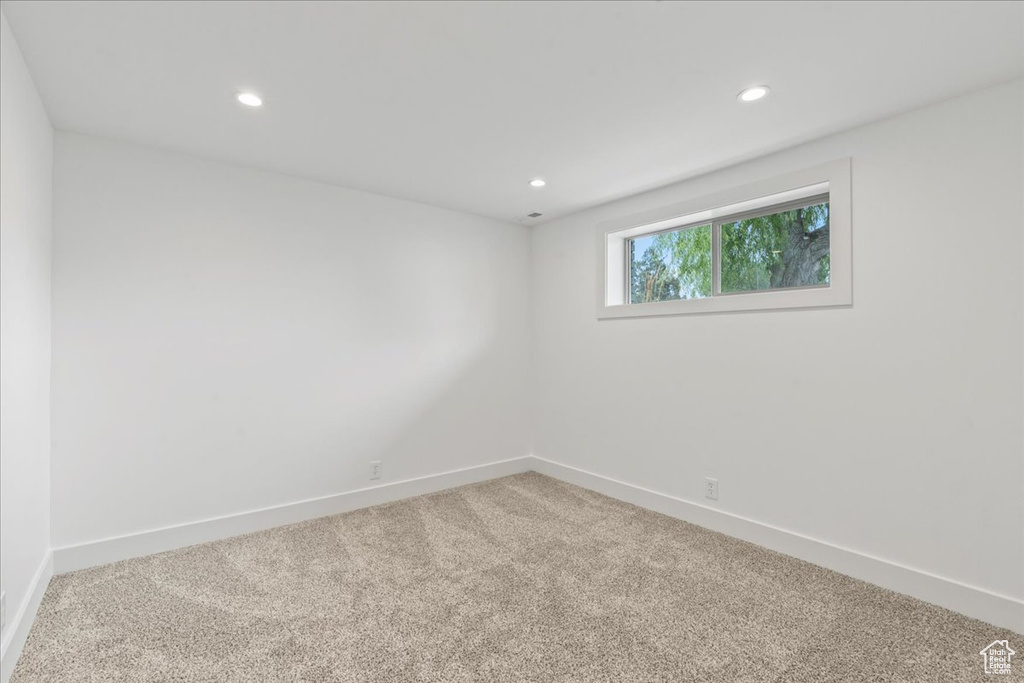 Empty room featuring light colored carpet