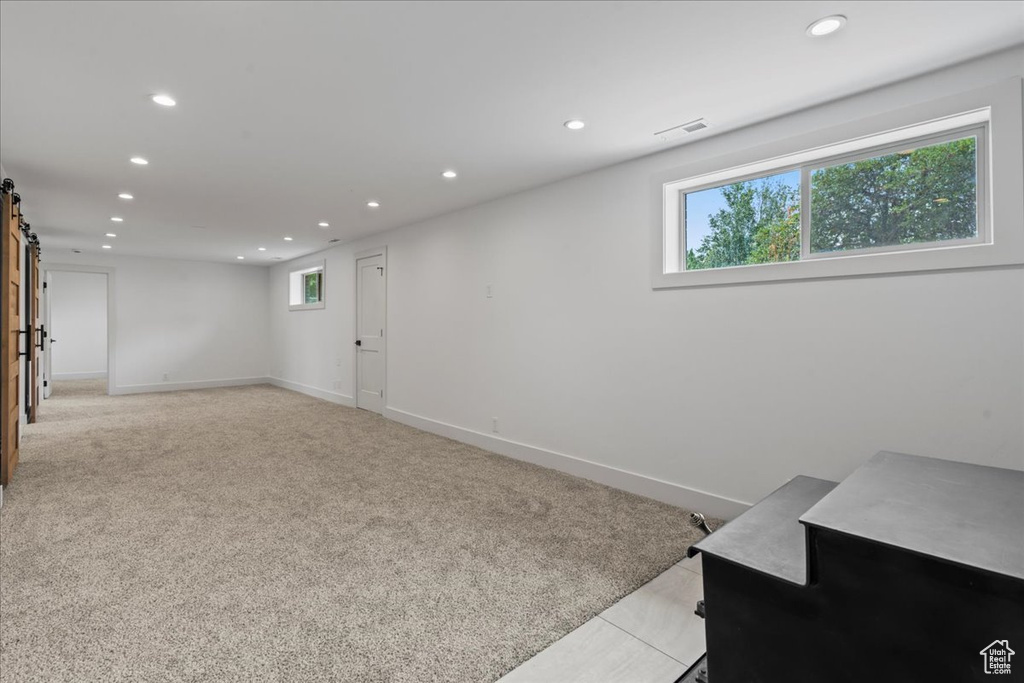 Interior space featuring a barn door and light colored carpet