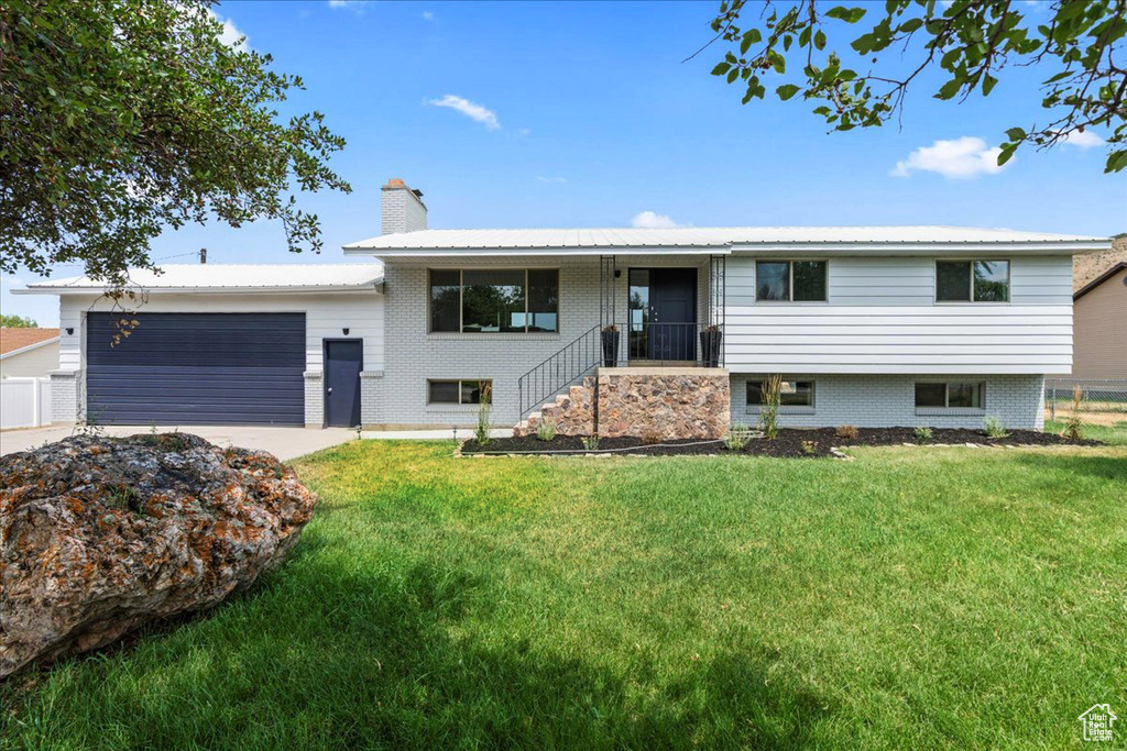 Split foyer home with a front yard and a garage