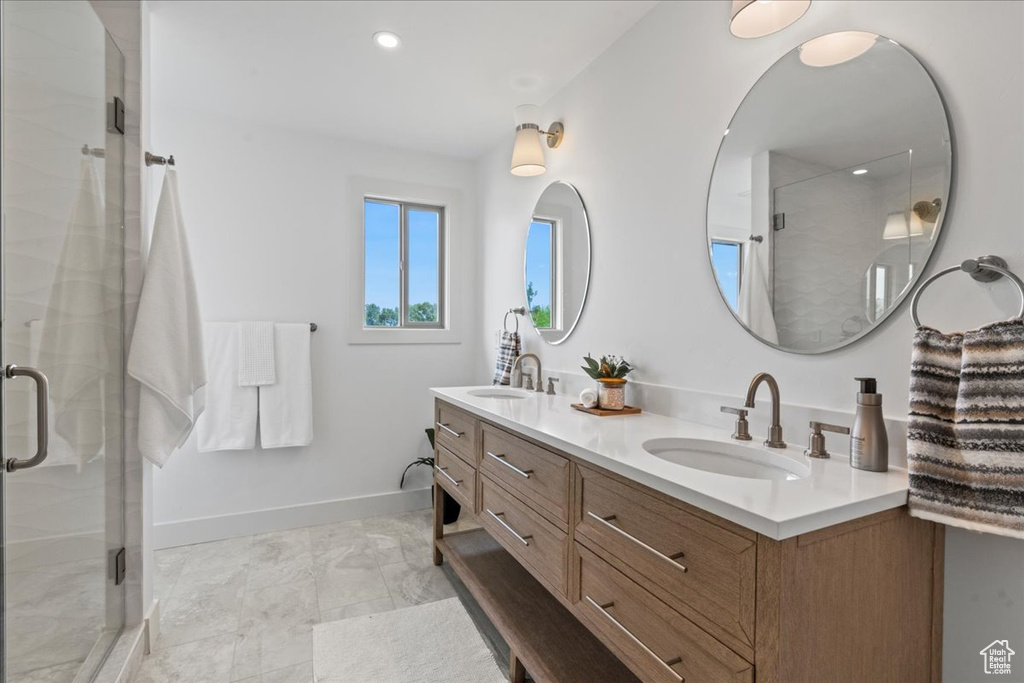 Bathroom featuring tile patterned floors, double sink vanity, and walk in shower