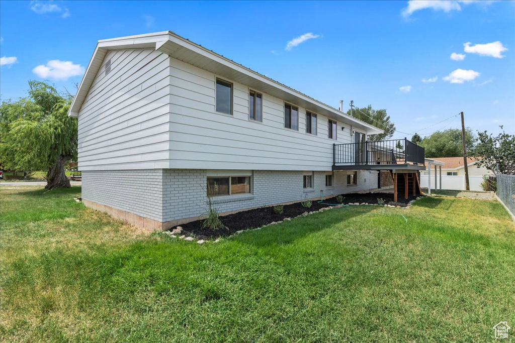 Rear view of property with a yard and a wooden deck