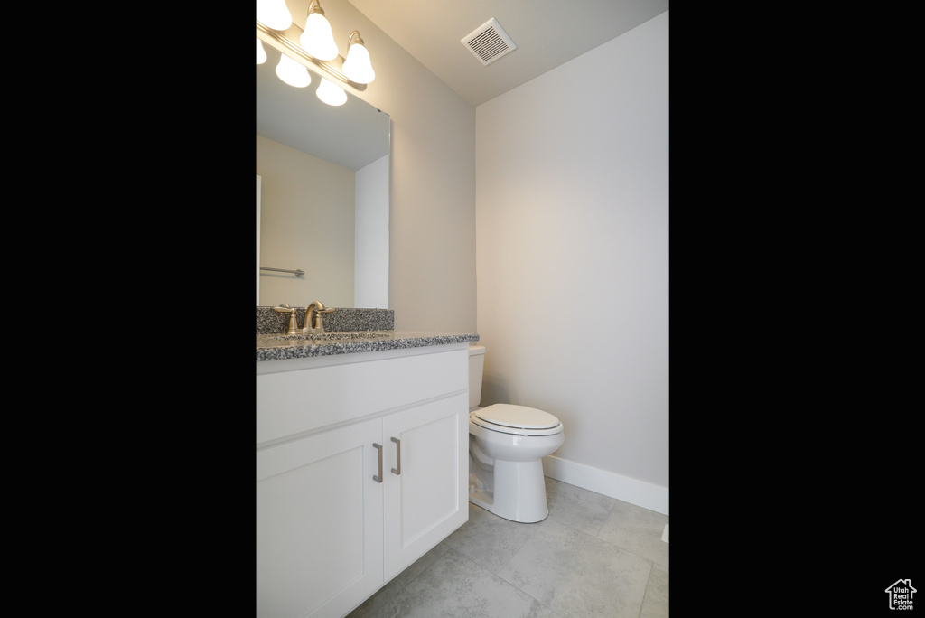 Bathroom with tile patterned floors, vanity, and toilet