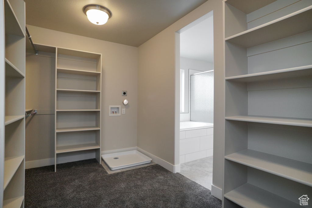 Walk in closet with dark colored carpet