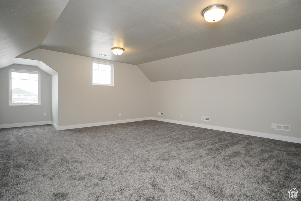 Bonus room with vaulted ceiling and carpet flooring