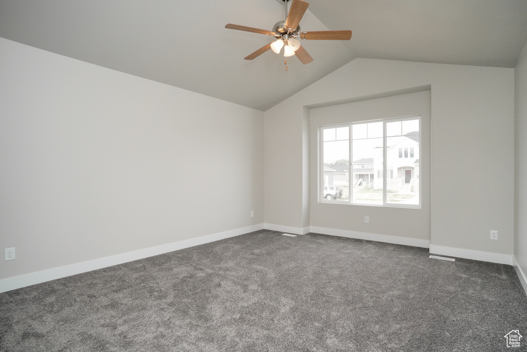 Carpeted spare room with lofted ceiling and ceiling fan