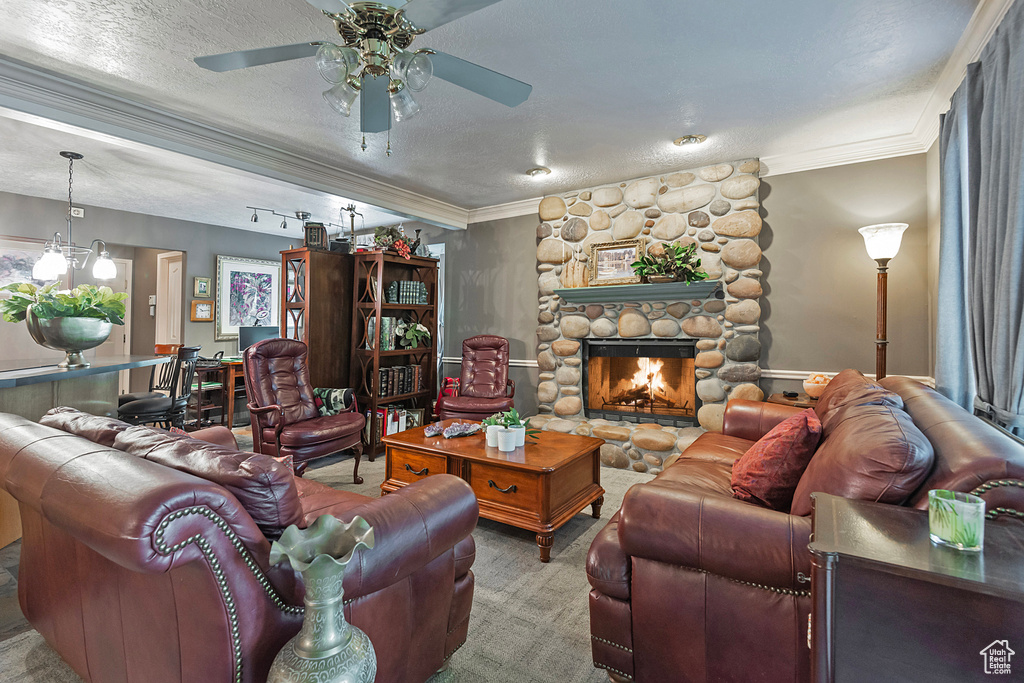 Living room with carpet flooring, a textured ceiling, a fireplace, and ceiling fan