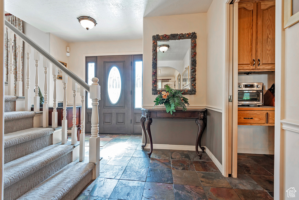 Entryway featuring tile patterned flooring and a textured ceiling