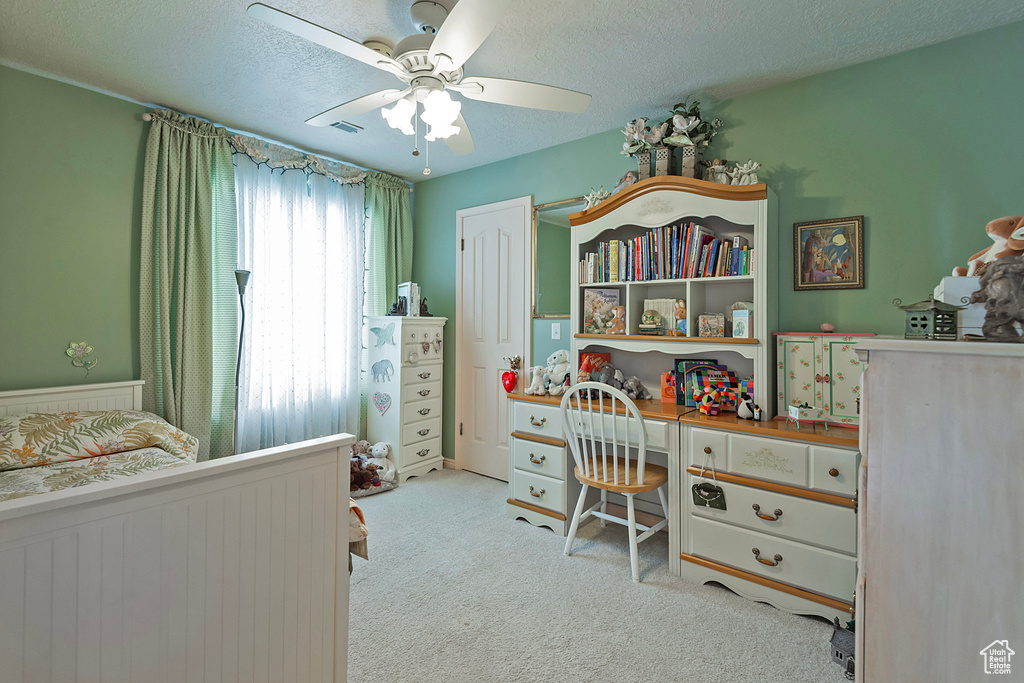 Bedroom featuring a textured ceiling, ceiling fan, and light colored carpet