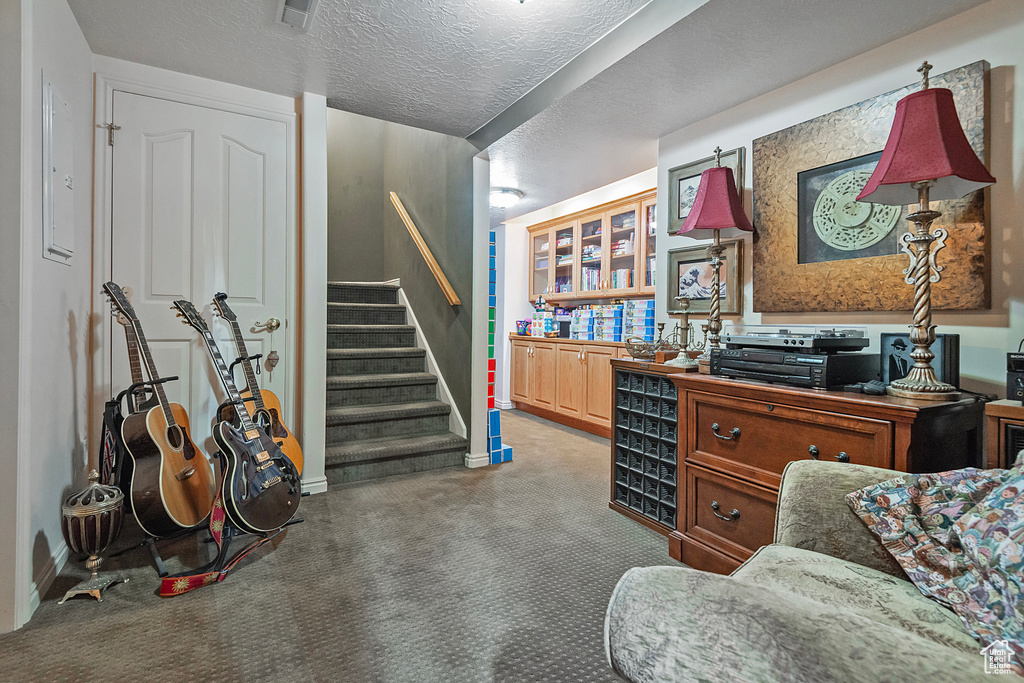 Home office with carpet flooring and a textured ceiling