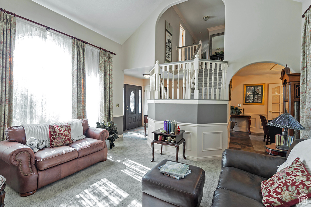 Tiled living room with high vaulted ceiling and a healthy amount of sunlight