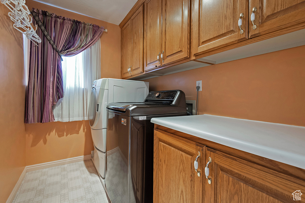 Laundry room with independent washer and dryer and cabinets