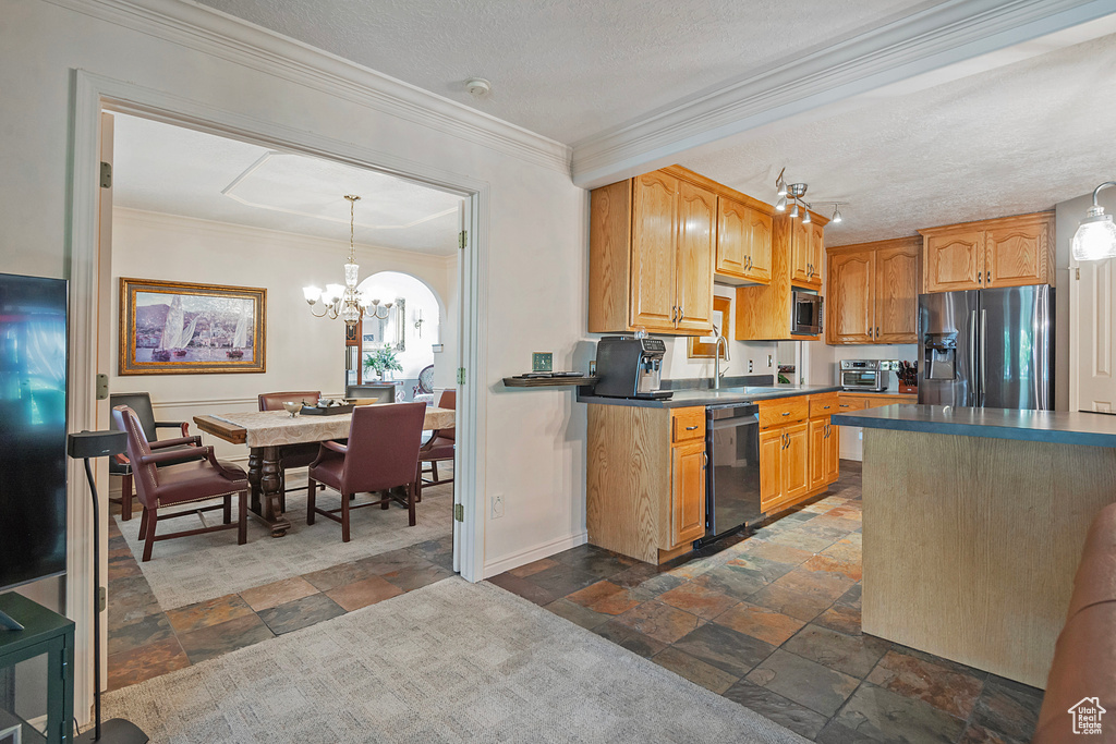 Kitchen with stainless steel appliances, a notable chandelier, hanging light fixtures, and dark tile patterned flooring