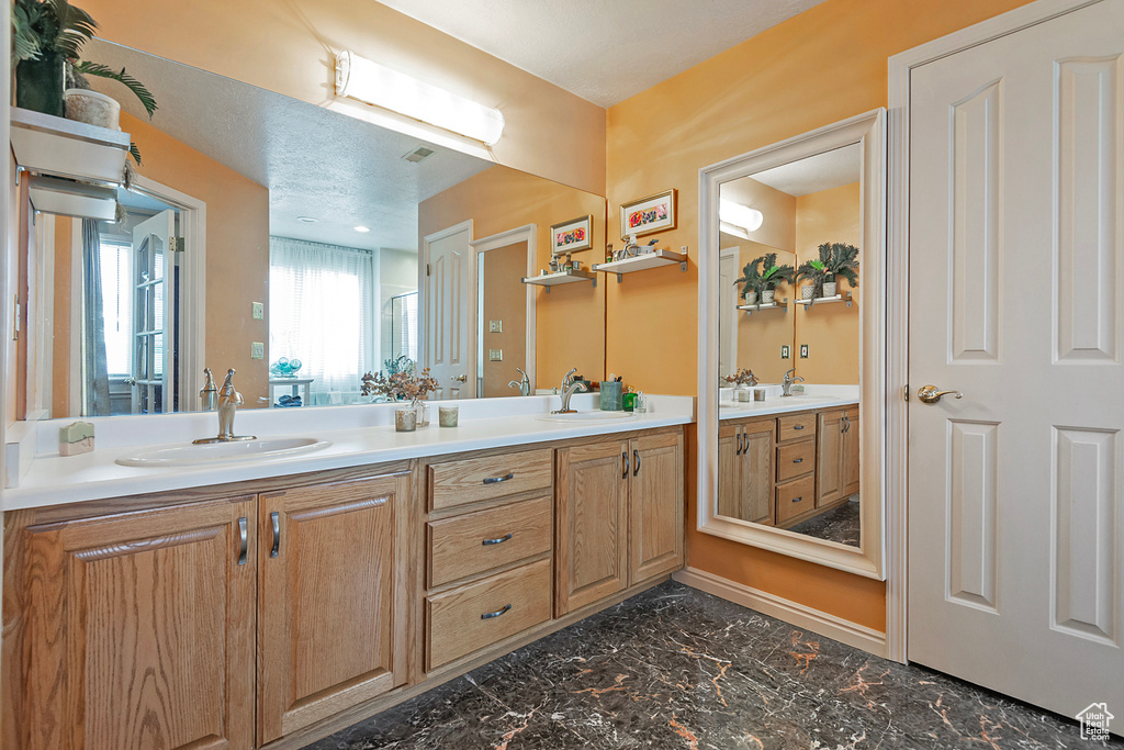 Bathroom with double vanity and tile patterned flooring