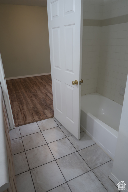 Bathroom with hardwood / wood-style flooring and tiled shower / bath