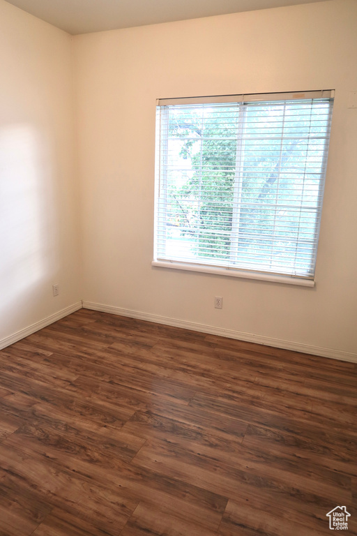 Empty room featuring dark hardwood / wood-style flooring