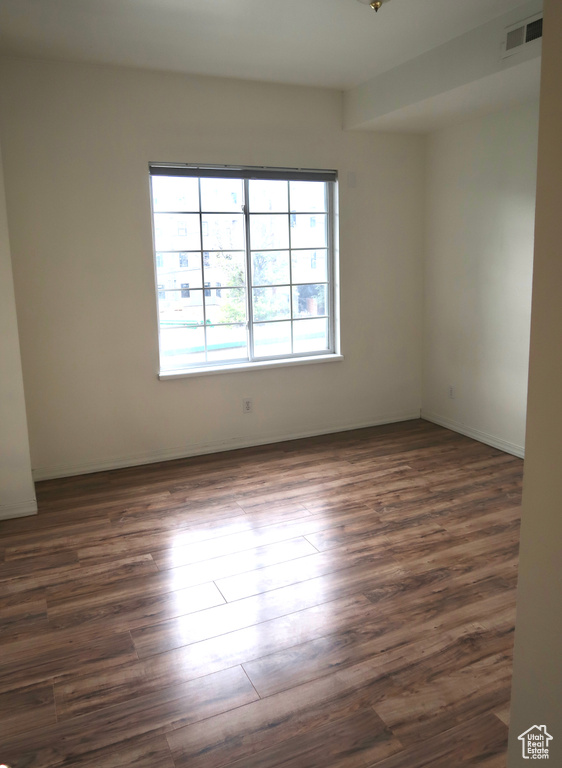 Empty room with dark hardwood / wood-style flooring