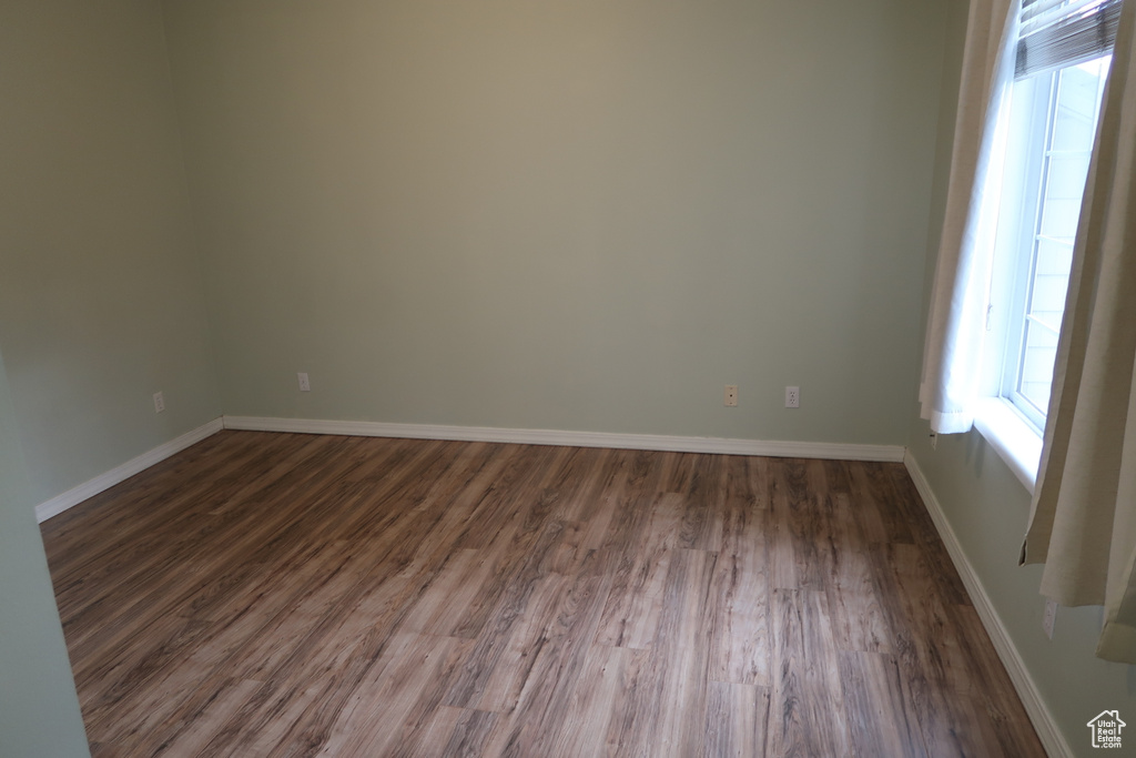 Spare room featuring dark wood-type flooring