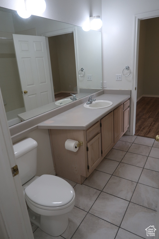 Bathroom featuring vanity, tile patterned flooring, and toilet