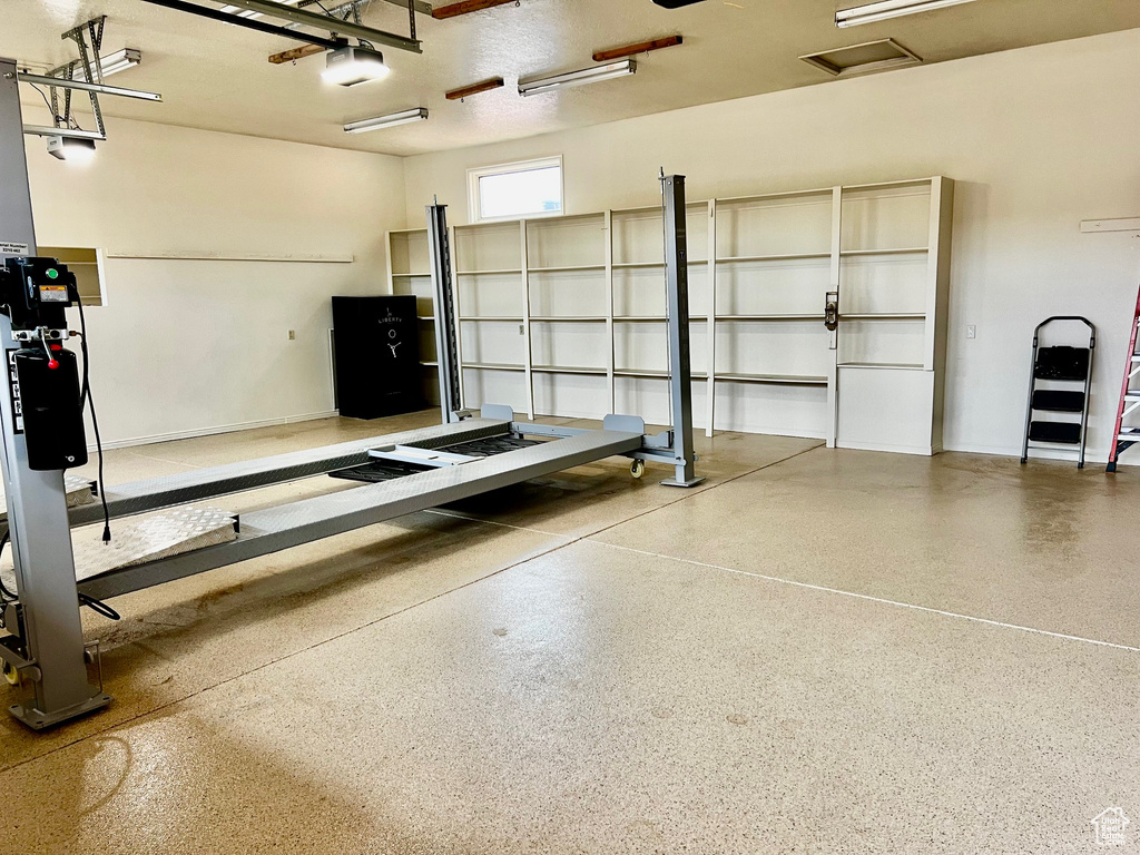 Garage with baseboards and a garage door opener