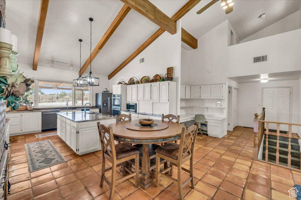Tiled dining area with ceiling fan, sink, high vaulted ceiling, and beamed ceiling